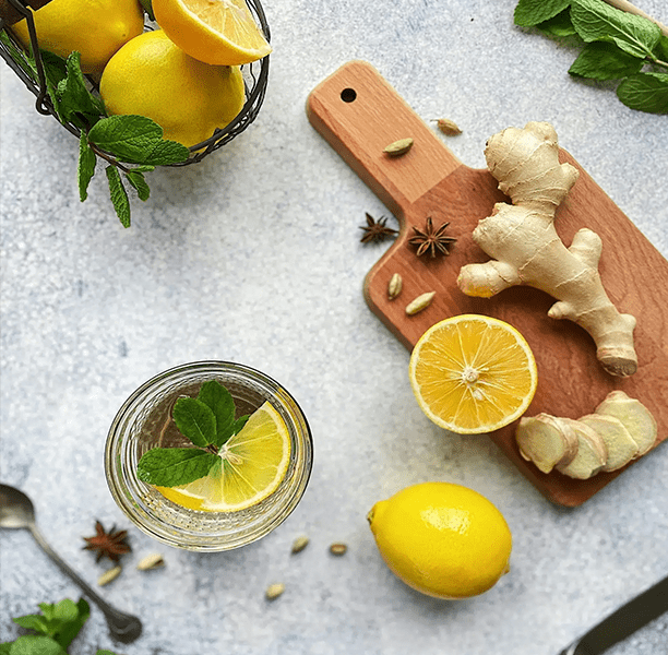 A cutting board with ginger and lemons on it
